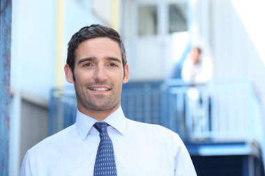 Man in a suit and tie outside his workplace clipart