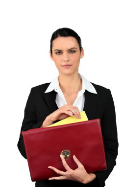 Smart woman taking a file out of a red briefcase clipart