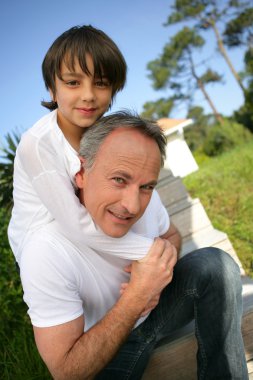 Little boy sat on his father's shoulders clipart