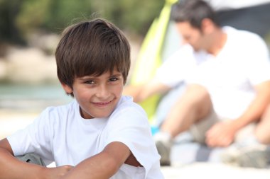 Young boy on a camping trip with his father clipart