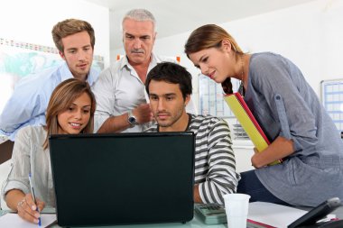 A bunch of gathered behind a laptop clipart