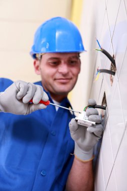 Electrician wiring a wall socket clipart