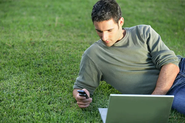 在草地上，用电脑的人 — 图库照片