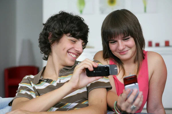 Adolescentes olhando para fotos em seus telefones celulares — Fotografia de Stock