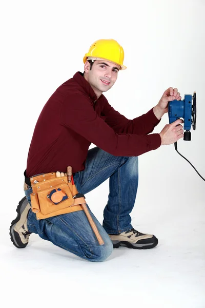 Carpinteiro economizando tempo usando lixadeira elétrica — Fotografia de Stock