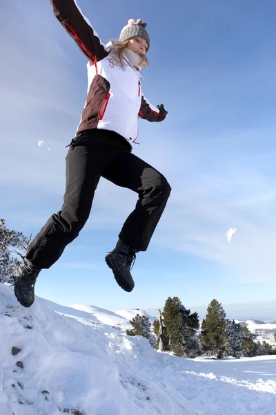 Жінка стрибає на купу снігу — стокове фото
