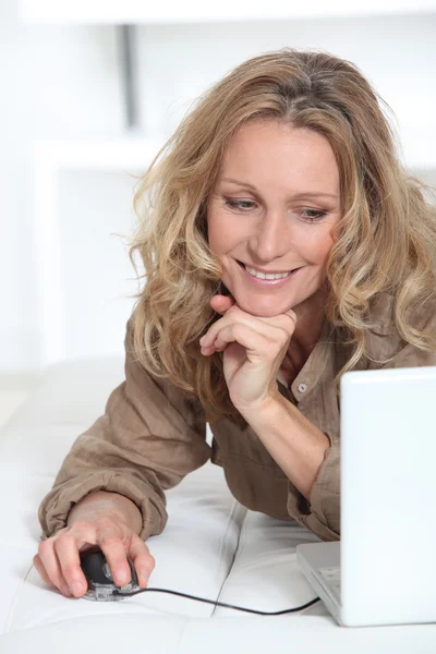 Mujer rubia en casa enviando e-mail — Foto de Stock