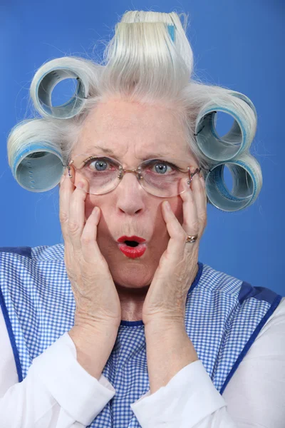 Avó de olhos azuis com encrespadores de cabelo gigantes — Fotografia de Stock
