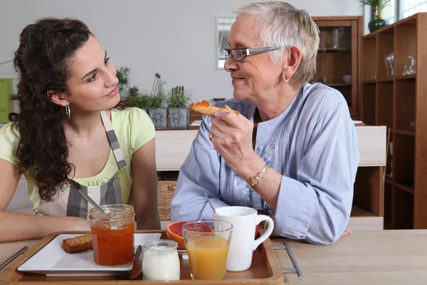 Бабушка и внучка завтракают — стоковое фото
