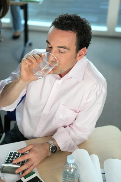 Mann trinkt Wasser bei der Arbeit — Stockfoto