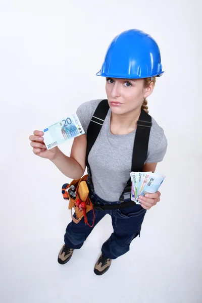 Female laborer holding wad of bills — Stock Photo, Image