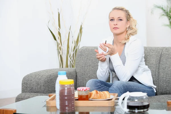 Mulher sentada em casa tomando café da manhã — Fotografia de Stock