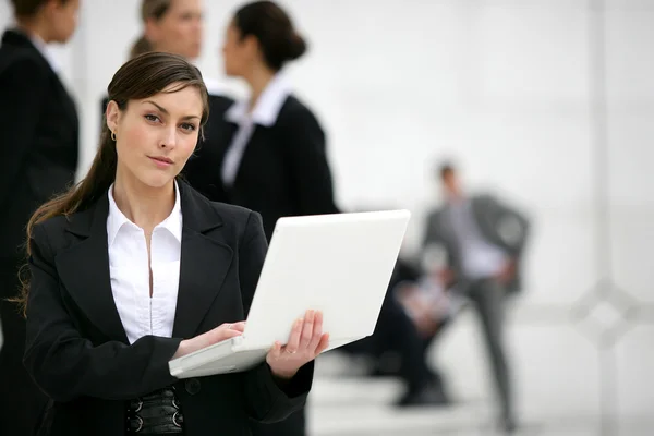 Femme d'affaires avec ordinateur portable debout en dehors du lieu de travail — Photo