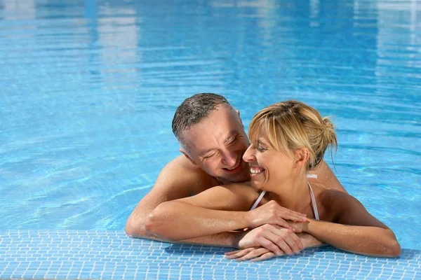 Pareja abrazándose en la piscina — Foto de Stock