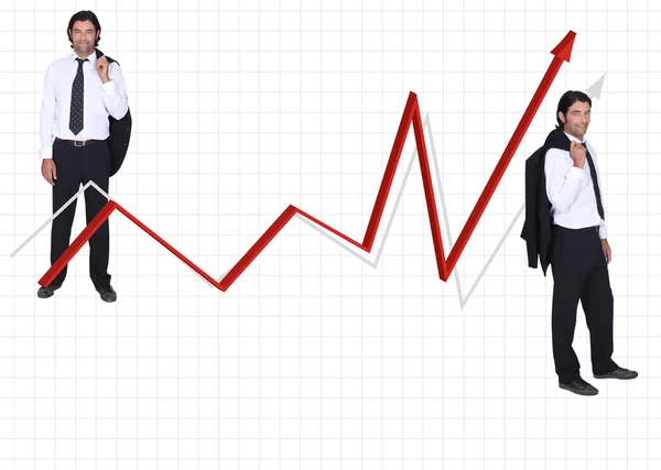 Kleiner formaat man in de jas en stropdas aan weerszijden van de rode pijl tegen grafiek — Stockfoto