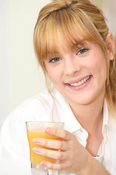 Blond kobieta pije sok pomarańczowy — Zdjęcie stockowe