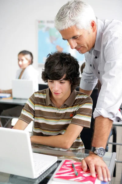 Professor ajudando aluno do sexo masculino — Fotografia de Stock
