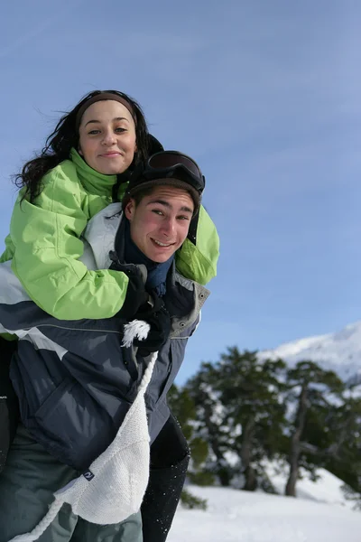 Lachende jongen met zijn vriendin op zijn rug — Stockfoto