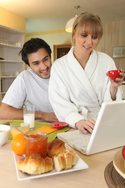 Пара снідає і робить комп'ютер — стокове фото