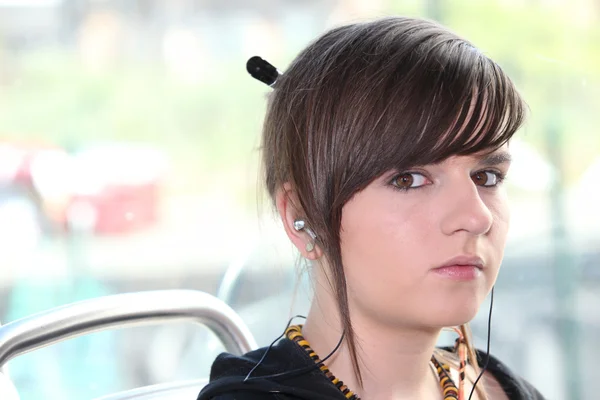 Closeup of girl with earphones sitting on a tram — Stock Photo, Image
