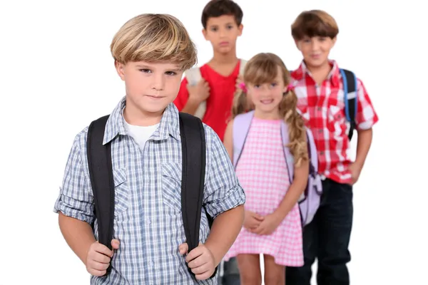 Fyra skolbarn med ryggsäckar — Stockfoto