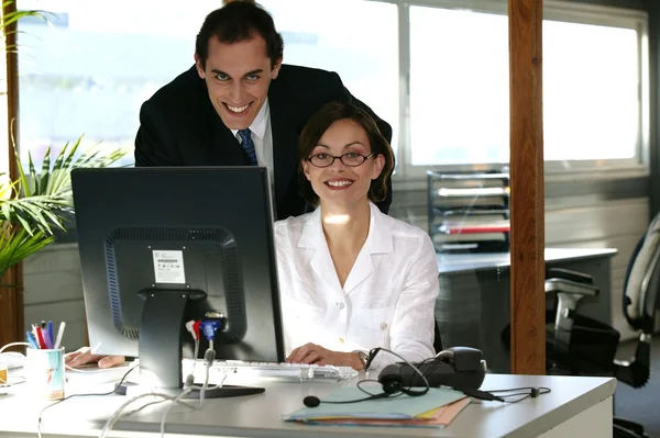 Business duo working in front of a computer — Stock Photo, Image