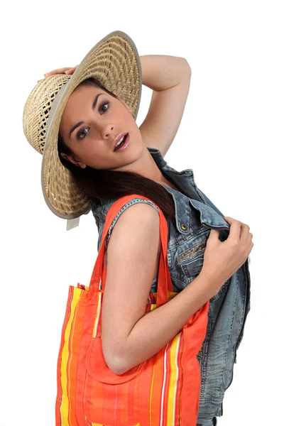 Жінка з сумкою в солом'яному капелюсі — стокове фото