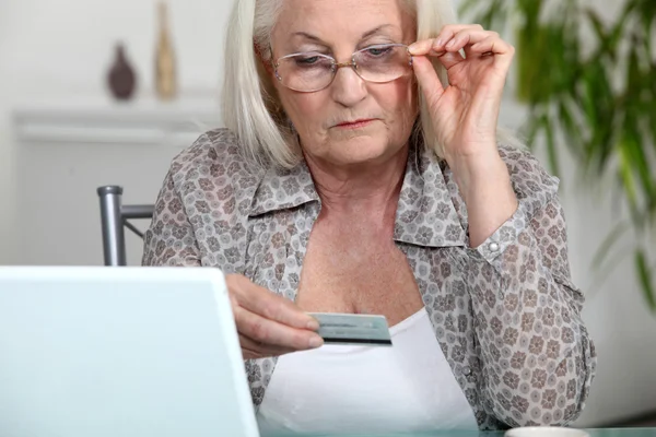 Ηλικιωμένη γυναίκα χρησιμοποιώντας την πιστωτική κάρτα σε απευθείας σύνδεση — Φωτογραφία Αρχείου
