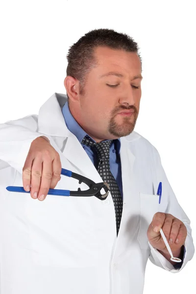 Стоматолог держит зеркало и плоскогубцы — стоковое фото