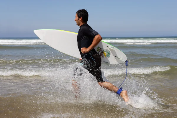 Surfer läuft mit Brett — Stockfoto