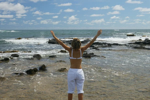 Mulher estava junto ao mar com os braços erguidos — Fotografia de Stock