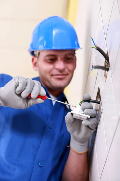 Eletricista fiação de uma tomada de parede — Fotografia de Stock