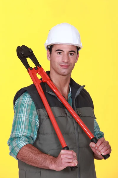 Stavební dělník drží kleště. — Stock fotografie