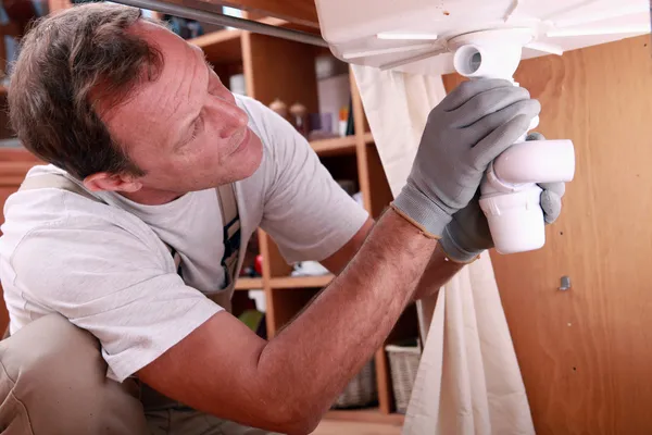 Hombre instalando los residuos en un fregadero de cocina —  Fotos de Stock