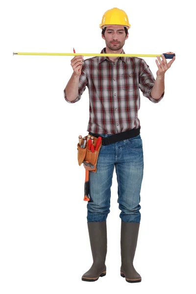 Construtor com uma fita métrica — Fotografia de Stock