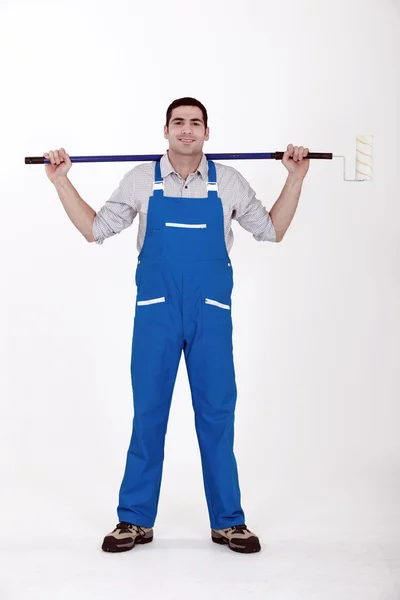 Man stood with extended paint roller — Stock Photo, Image