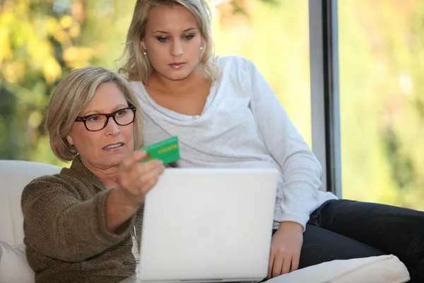 Elderly woman using a card online — Stock Photo, Image