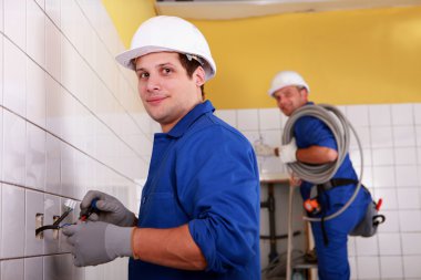 Men fitting electrical sockets clipart