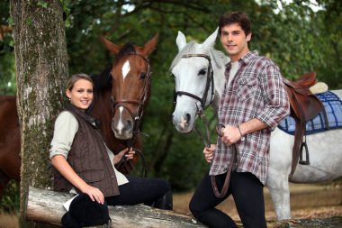 Young couple with two horses clipart