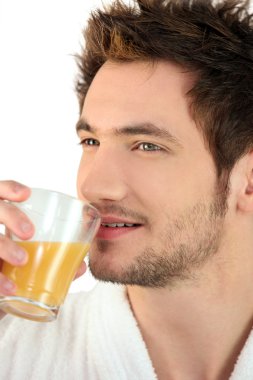 Man drinking a glass of orange juice clipart
