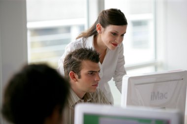 Two businesspeople looking attentively at computer screen clipart