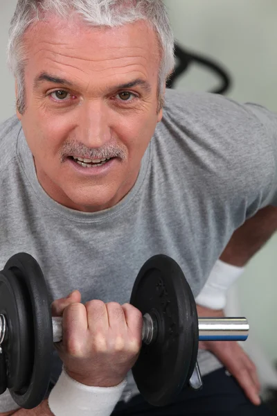 Mature man lifting weight — Stock Photo, Image