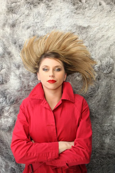 床に横たわっての赤いコートを持つ女性 — ストック写真