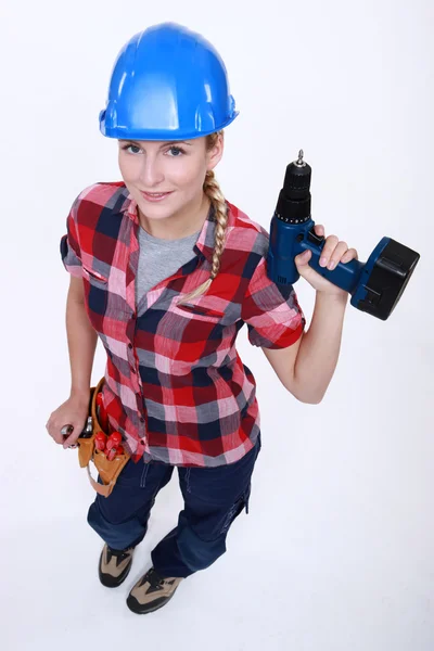 Unga hantverkerska innehar en borr — Stockfoto