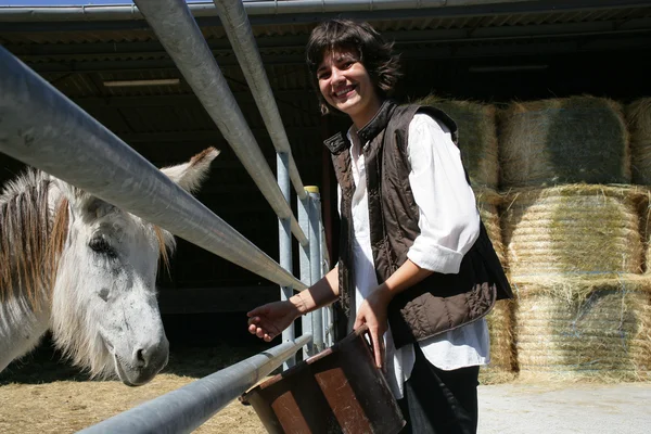Женщина-фермер стояла у ограждения для лошадей — стоковое фото