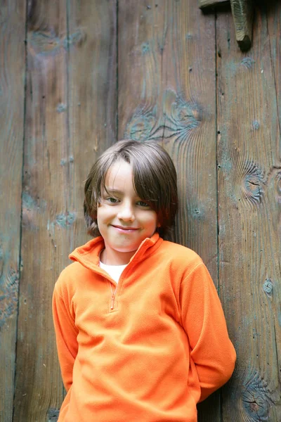 El chico estaba junto a una gran puerta de madera — Foto de Stock