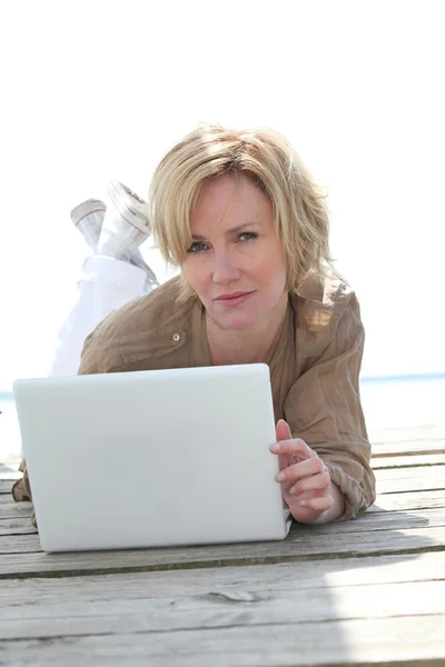 Женщина на ноутбуке снаружи — стоковое фото