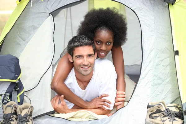 Casal interracial em uma tenda de lona — Fotografia de Stock