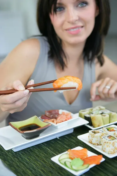 Брюнетка ест суши — стоковое фото