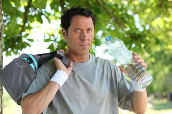 Sportlicher Mann mit Wasserflasche — Stockfoto